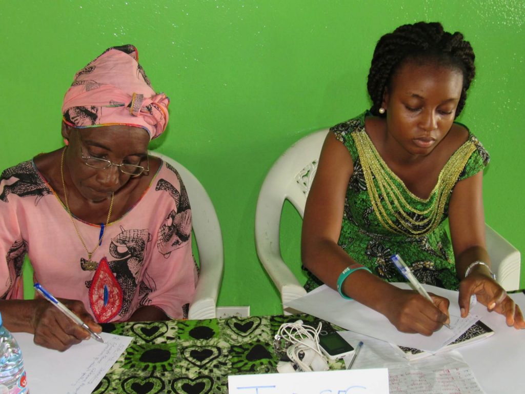 Two ladies writing at a table at Mineke Foundation