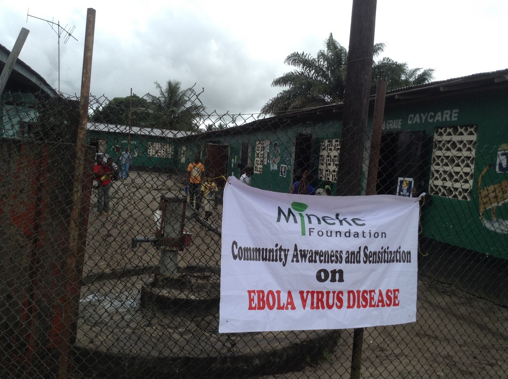 A banner informs community members about Mineke Foundation's Ebola awareness meetings