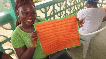 A Woman's Club member holds up a patchwork square
